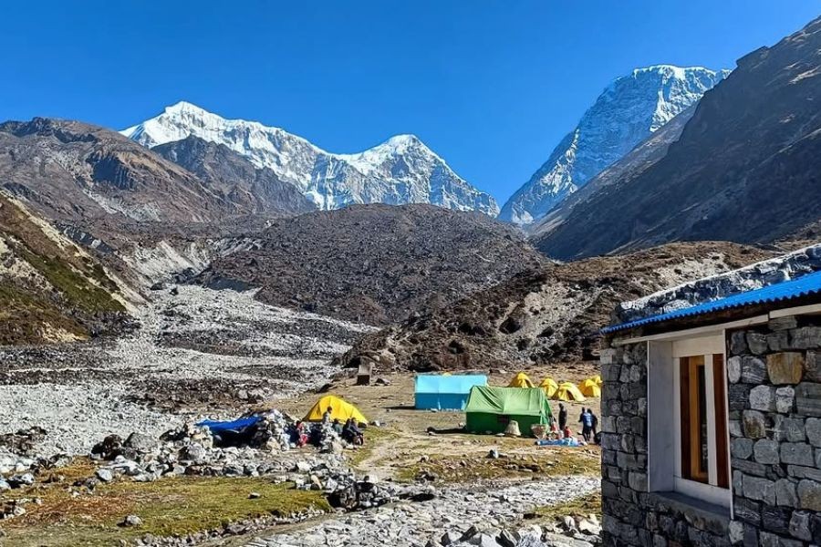 Mountain teahouse lodge with prayer flags and Himalayan peaks in background